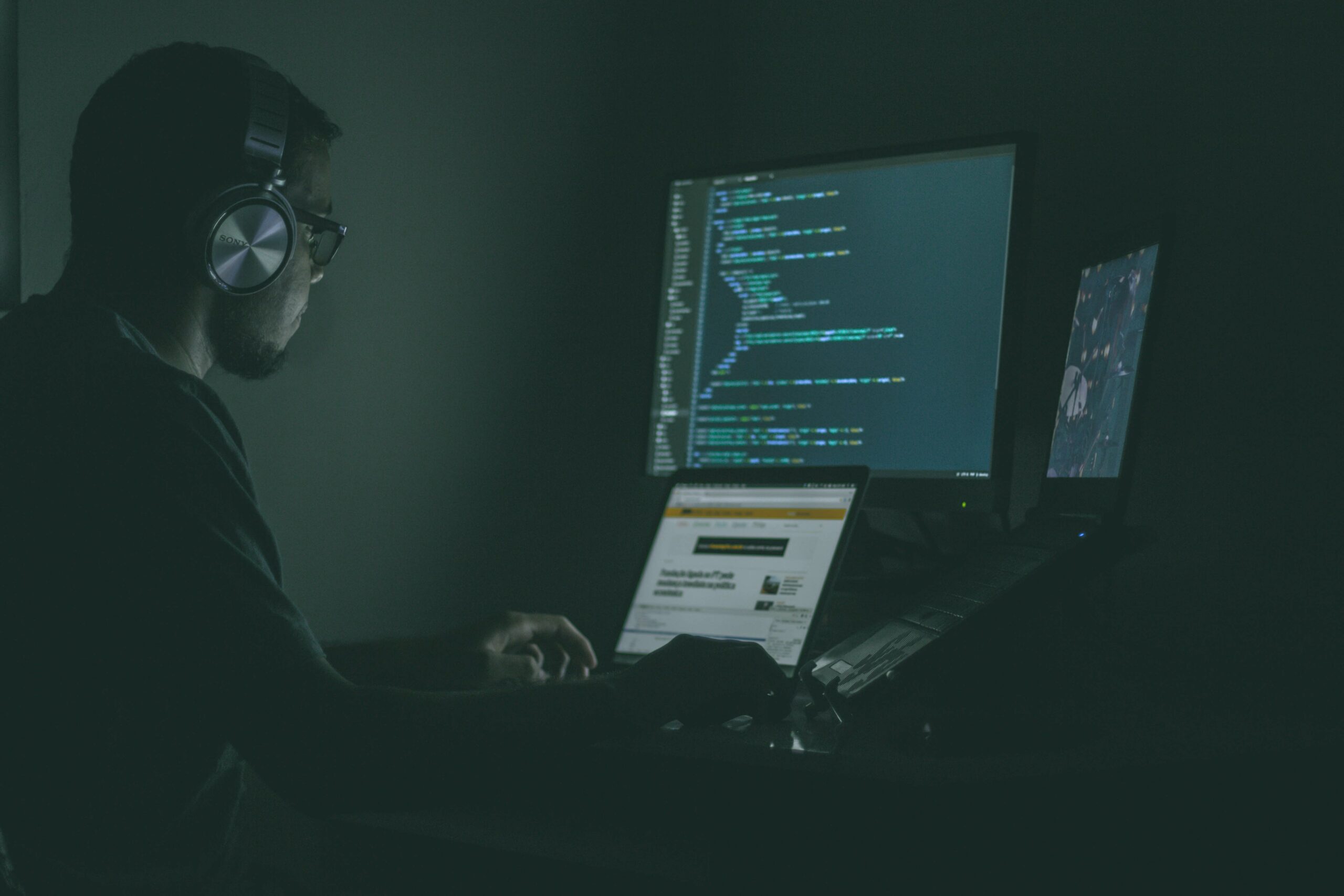 Man in front of several computer screens.