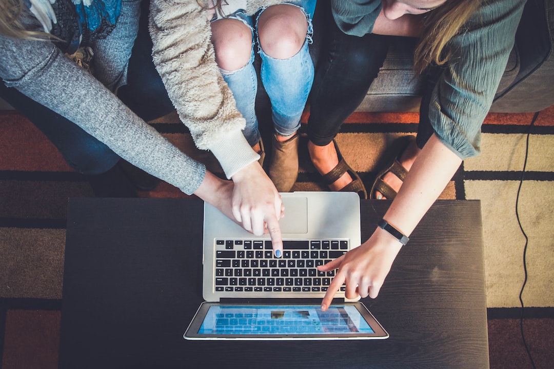 Several people pointing to a computer